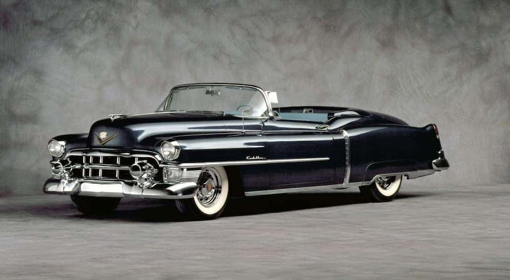 Side angled view of a blue 1953 Cadillac Series 62 Eldorado in a grey room