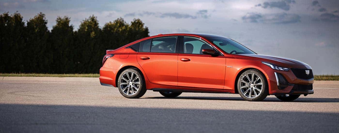 Side view of an orange 2020 Cadillac CT5-V parked in an empty lot
