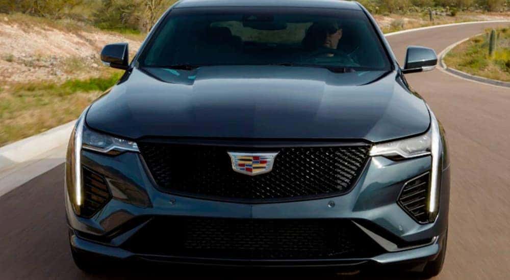Close-up of the front end of a grey 2021 Cadillac CT4-V driving from a used car dealership