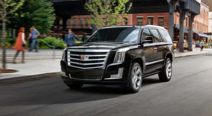 A black 2020 Cadillac Escalade is shown driving on a city street.