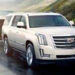 A white 2020 Cadillac Escalade is shown towing a boat.