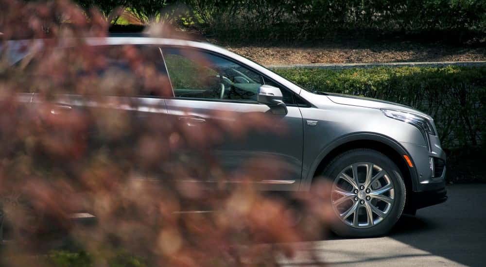 A silver 2020 Cadillac XT5 Sport is shown parked on an empty street.