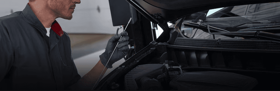 A Cadillac service technician performing maintenance on a vehicle