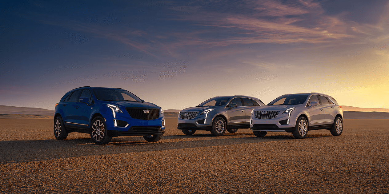 Three 2025 Cadillac XT5 SUVs lined up in a desert setting