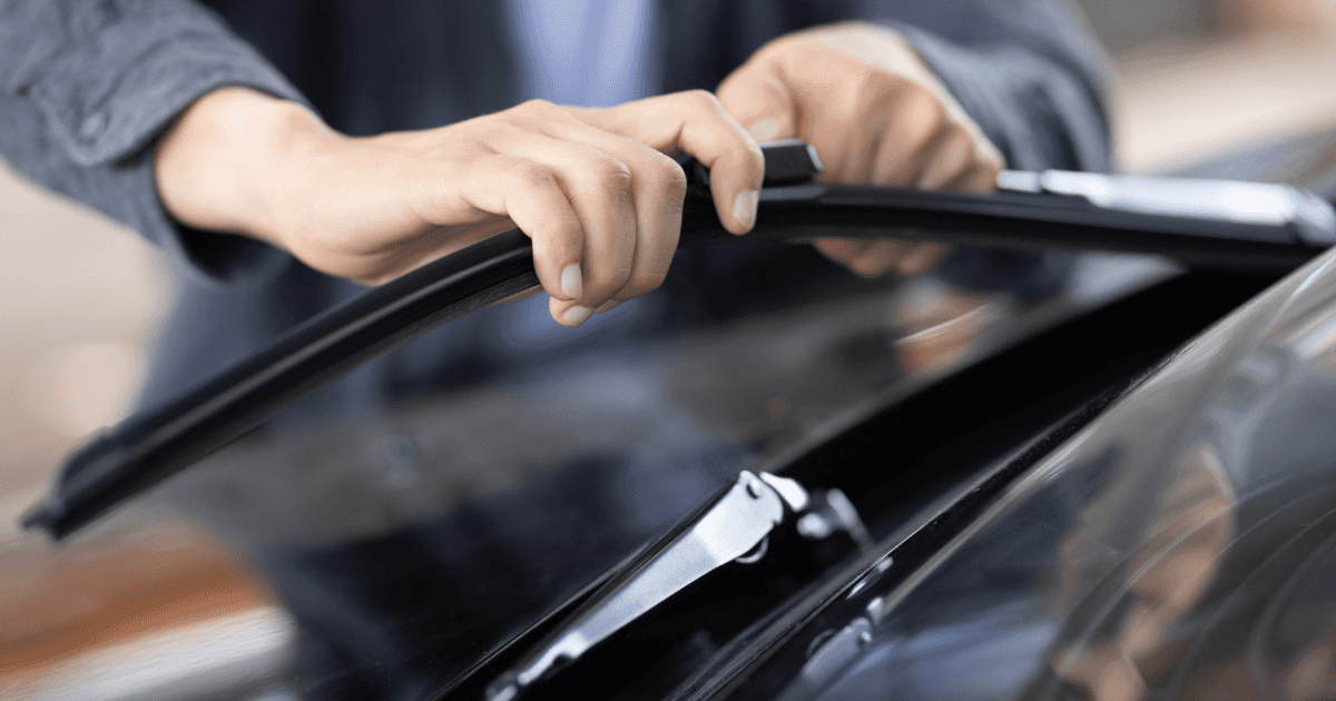 Technician replacing windshield wiper blades
