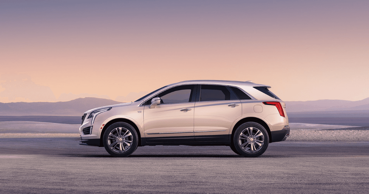 A side view of a white Cadillac XT5 in a flat area