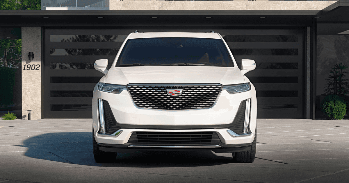 A front view of a white Cadillac XT6 parked in a driveway