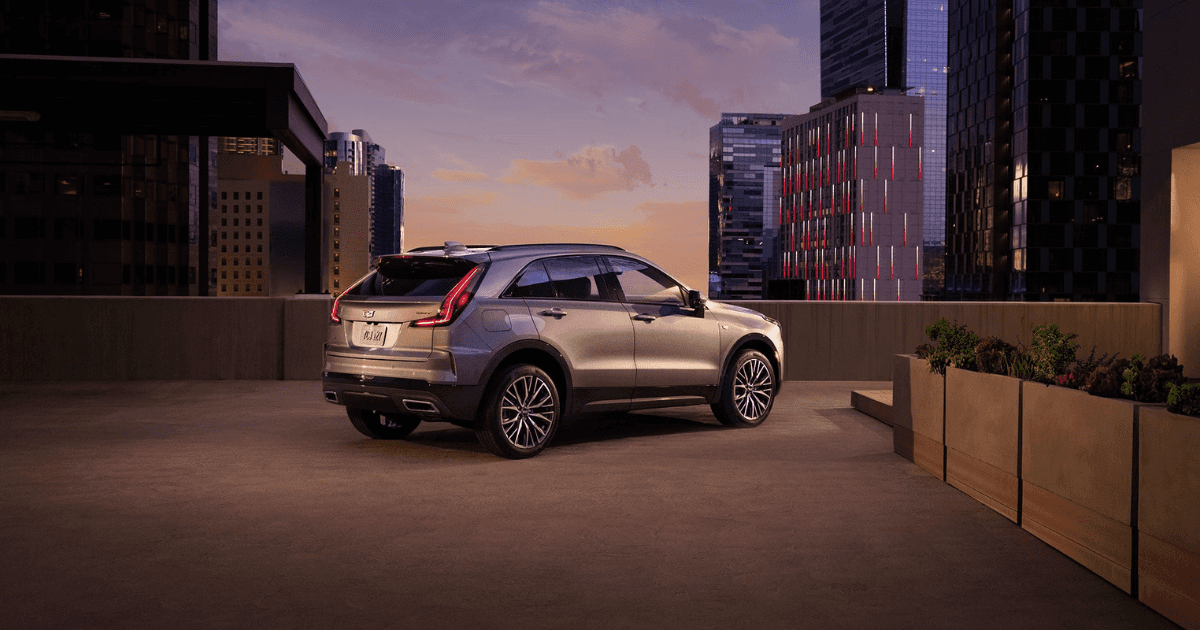 A silver Cadillac XT4 parked on a rooftop in a city