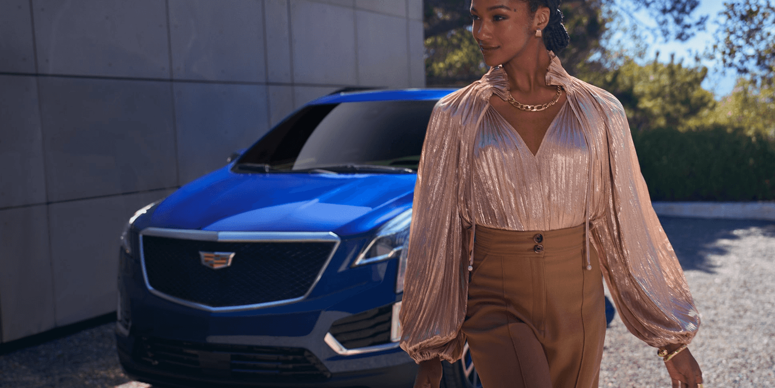 A woman in front of a blue Cadillac XT5