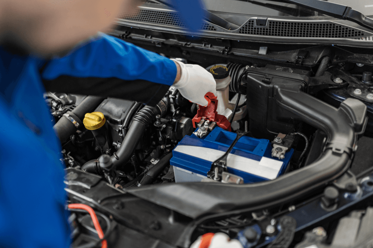 A mechanic performing maintenance on a vehicle's battery