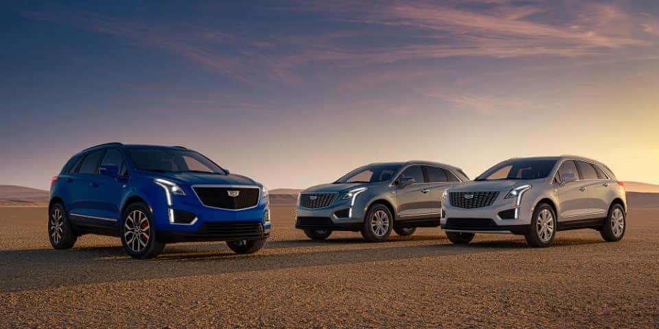 A blue, silver, and gray Cadillac XT5 on display in an open area