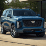 A blue Cadillac Escalade parked outside of a nice house