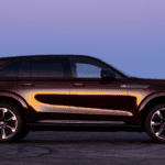 A maroon Cadillac IQ in profile in a desert at night