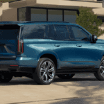 A blue Cadillac Escalade parked outside of a nice house