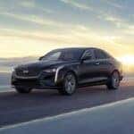 A black Cadillac CT4 driving down a long road