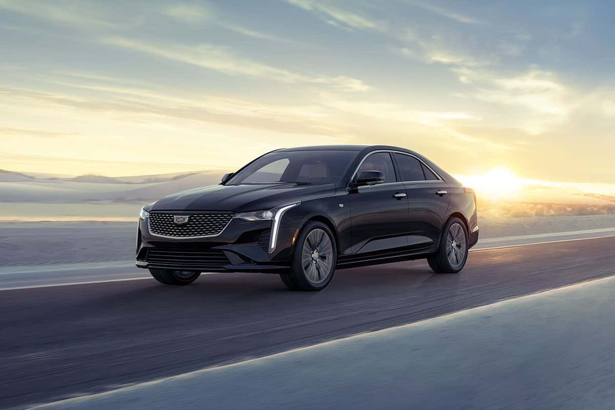 A black Cadillac CT4 driving down a long road