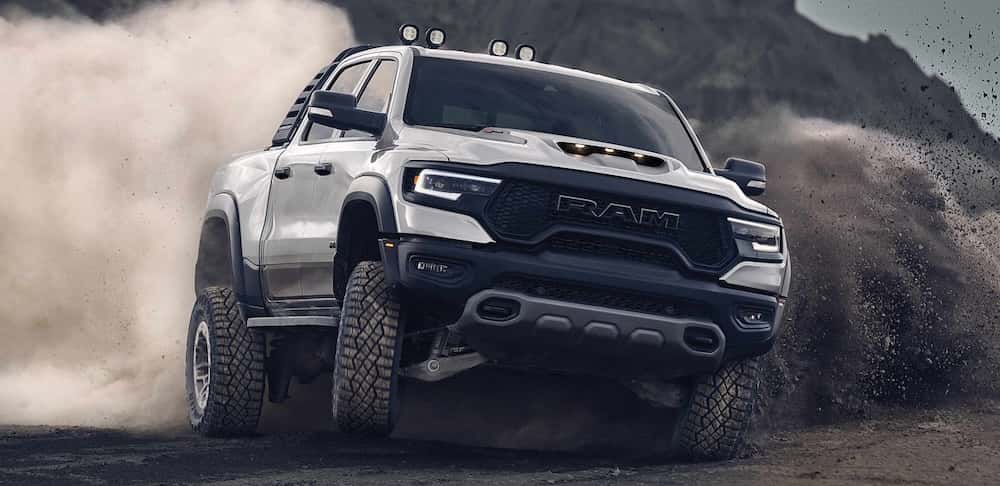 Dynamic front shot of a Ram TRX truck roaring on an off-road trail