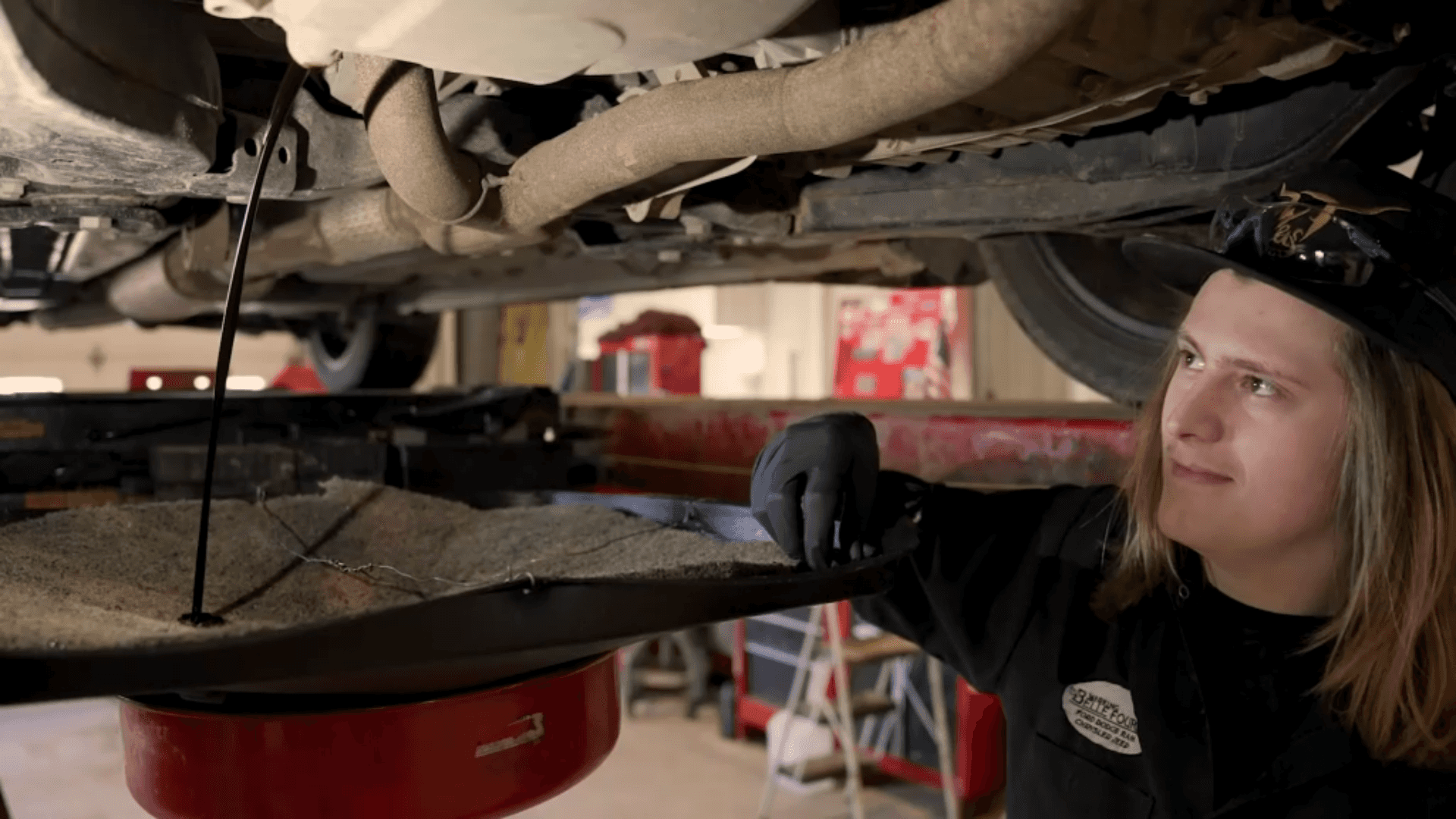 Lube Technician Pulling Drain Plug on Vehicle During Oil Change