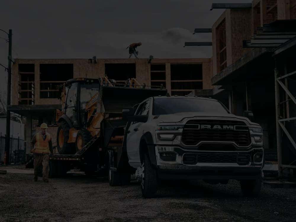 RAM Heavy Duty trucking pulling trailer with construction equipment
