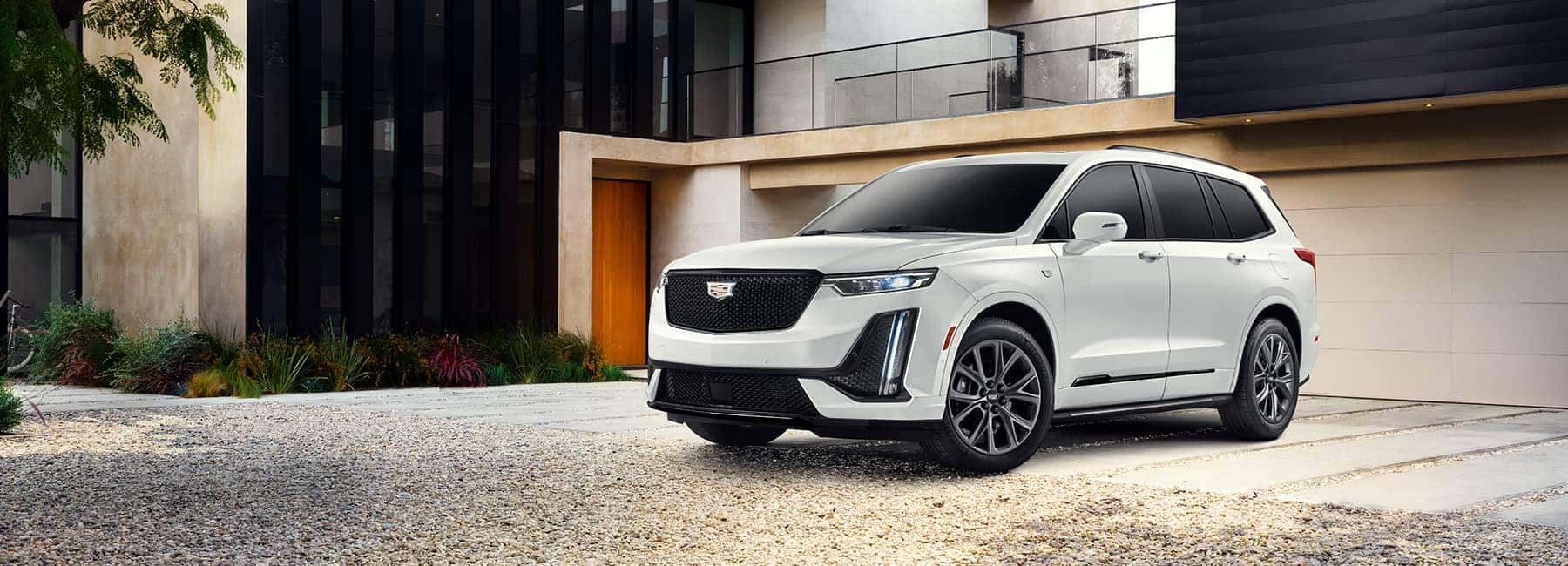 Cadillac EV parked in front of luxury home