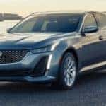 A silver Cadillac CT5 sits near a lake.