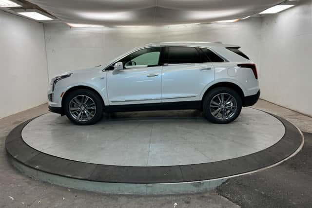 White 2026 Cadillac XT5 SUV shown in a showroom with a side profile view, showcasing versatility in St. George, UT