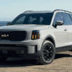 a white 2024 Telluride near a beach with water in the background