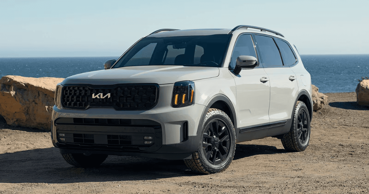 a white 2024 Telluride near a beach with water in the background