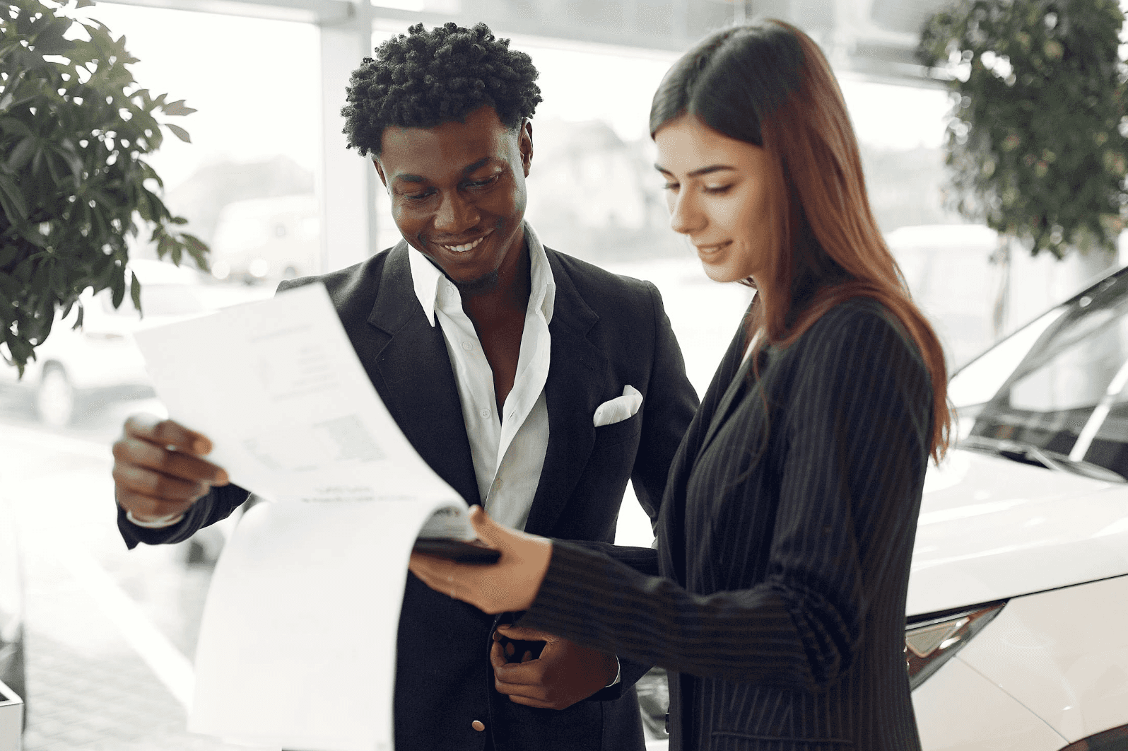 two people working out a lease deal in the car dealership