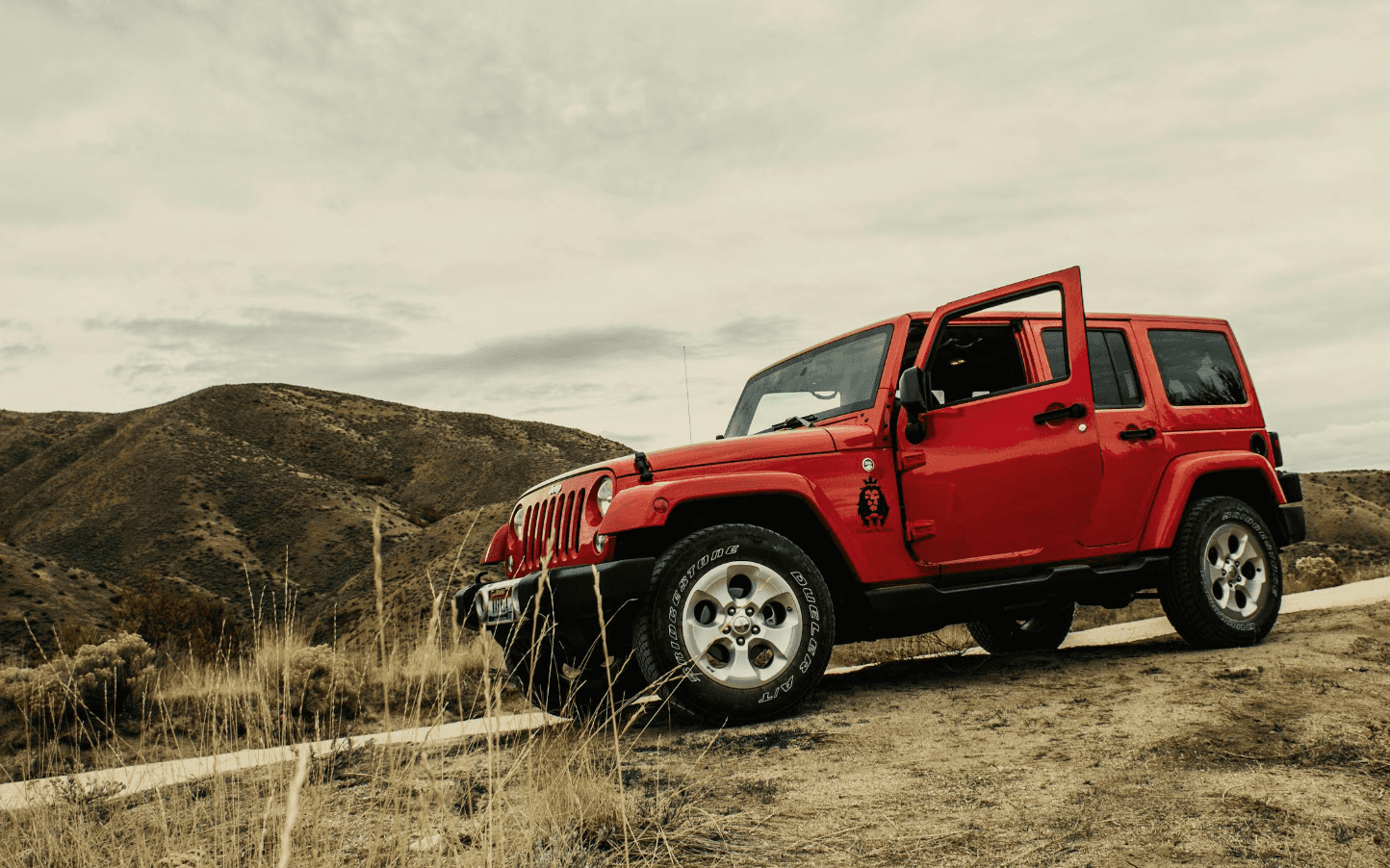 Red Jeep SUV on dirt road
