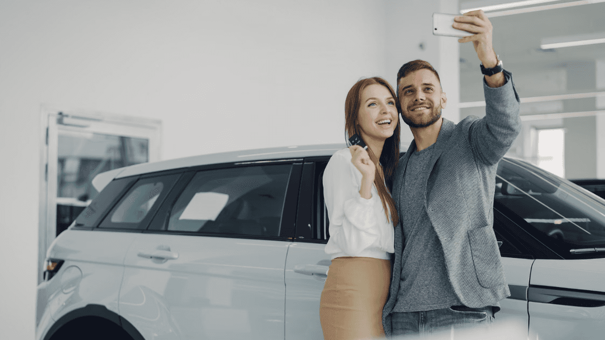 couple taking a selfie in front of a used car for sale near Buffalo
