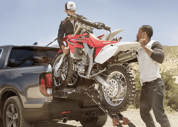 Honda Trucks two men carrying motorbike