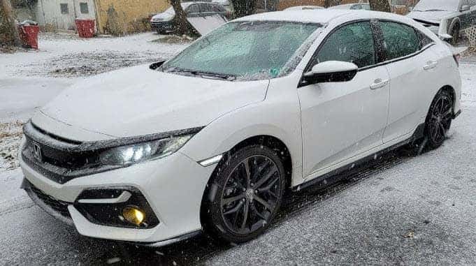 Honda Civic sport sedan driving through snowy Racine Wisconsin street